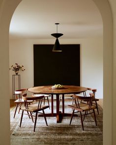 a dining room table with chairs and a blackboard in the background