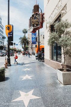 a star on the hollywood walk of fame with people walking down it and buildings in the background