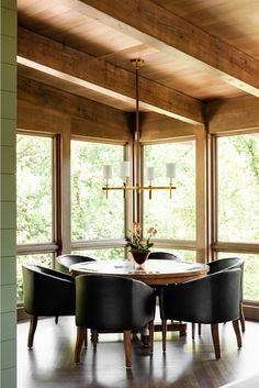 the dining room table is surrounded by black chairs