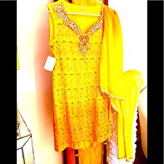 Brilliant Colors! 3 Piece Set: Dress/Dupatta/Churidar Dress: Embellished, Lined Length At Center Back: 34" Bust 18" Waist 17" Hip 18" 14" Side Openings Dupatta: 23" X 88" Churidar: Bright Yellow/Lightly Sequined Elastic At Back Waist/Metal Closure Length: 45" (Intended For Draping) Waist 14.5" Hip 19" New And Unworn/Tons Of Sequins/A Few Missing/Hardly Noticeable Absolutely Beautiful Made In India Rayon Viscose Polyester Mirrored/Crystal/Sequin Embellishment Dry Clean Only Yellow Sleeveless Set For Eid, Yellow Embellished Designer Wear Sets, Yellow Kurta With Mirror Work For Navratri, Designer Yellow Embellished Sets, Yellow Embellished Sharara For Navratri, Embellished Yellow Sharara For Eid, Gold Embellished Kurta For Navratri, Navratri Embellished Gold Kurta, Navratri Gold Embellished Kurta