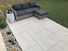 a couch and chair sitting on top of a stone patio