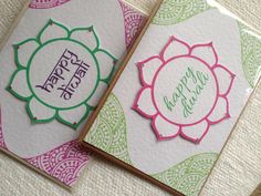 two cards with flowers on them sitting next to each other