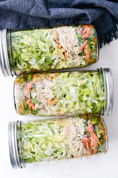 three mason jars filled with different types of salads and veggies in them