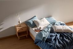 a bed with blue sheets and pillows on it