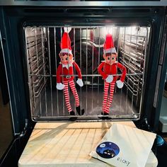 two elfs are in the oven and one is looking at something