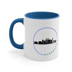 a white and blue coffee mug with the words run city in front of a skyline