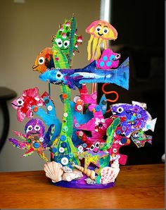 a vase filled with lots of colorful fish on top of a wooden table