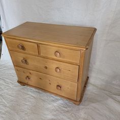 a wooden dresser sitting on top of a white sheet