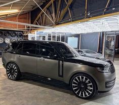 a range rover parked in a showroom next to other cars and tires on display