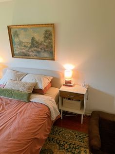 a bed sitting next to a night stand with two lamps on top of it