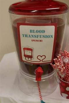 a plastic container filled with lots of candy next to a red and white sign that says blood transfusionon punch