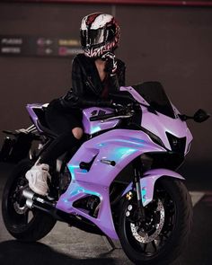 a woman sitting on top of a purple motorcycle