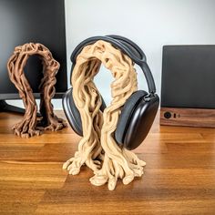 a pair of headphones sitting on top of a wooden table next to a computer monitor