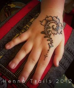 a person's hand with a henna tattoo design on it, and the fingers