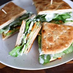 a sandwich cut in half sitting on top of a white plate