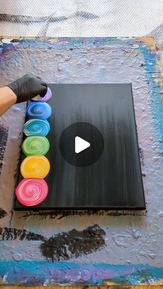 someone is painting on a canvas with different colors