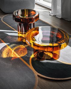 two glass tables sitting on top of a wooden floor