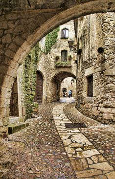 an alley way with stone buildings and cobblestones