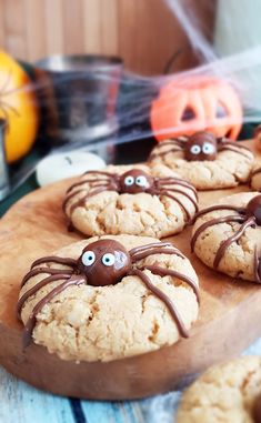 cookies decorated with chocolate spider eyes on a wooden board