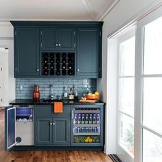 a kitchen with dark green cabinets and wood flooring, along with an ice chest