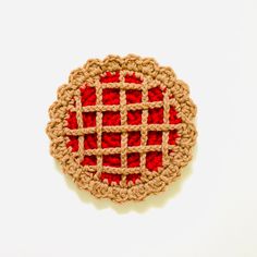 a crocheted red and beige object on a white surface