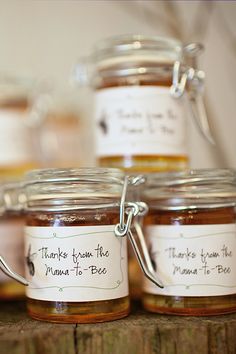 jars filled with honey sitting on top of a wooden table