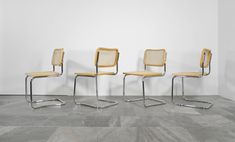 three chairs sitting next to each other in a room with tile flooring and white walls