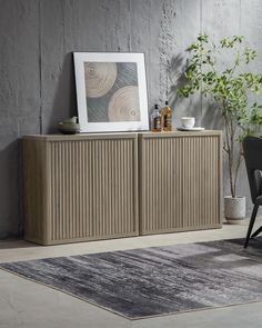 a chair sitting next to a wooden cabinet on top of a carpeted floor in front of a gray wall