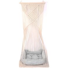 a white hammock hanging on the wall with a gray pillow in front of it