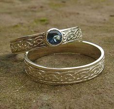 two gold wedding bands with a blue stone in the middle