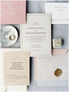 the wedding stationery is laid out on top of each other, including an envelope and ring