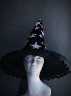 This bewitching black witch hat is adorned with glittering silver stars and delicate lace trim, perfect for those looking to shine with a touch of elegance at their next Halloween event. Age Group/Gender - Adult/Unisex Size/Type - One size fits all adults Hat Base Color - Black Hat Material - Fabric Witchy Winter Hats For Party, Witchy Wide Brim Costume Hat For Party, Witchy Winter Party Costume Hats And Headpieces, Mystical Halloween Costume Hats And Headpieces For Party, Mystical Black Costume Hats And Headpieces, Witchy Fitted Party Hat, Witchy Style Mini Hats With Curved Brim For Party, Fitted Witchy Party Hat, Witchy Mini Hats With Curved Brim For Party