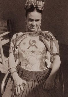 an old photo of a woman with tattoos on her chest and hands behind her back