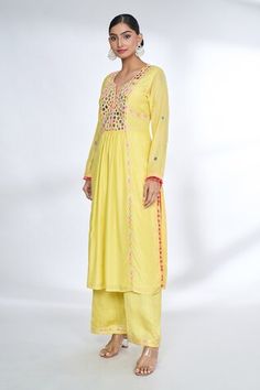 Yellow front gathered kurta with mirror embroidered yoke and sleeves with potli borders. Comes with coordinating palazzo. - Aza Fashions Unstitched Bohemian Kurta With Gota Work, Bohemian Unstitched Kurta With Gota Work, Bohemian Kurta With Gota Work For Navratri, Bohemian Gota Work Kurta For Navratri, Bohemian Wedding Kurta With Dori Work, Bohemian Anarkali Set With Dori Work, Yellow Long Sleeve Kurta With Mirror Work, Festival Long Sleeve Palazzo Set With Dori Work, Yellow Bohemian Kurta With Cutdana