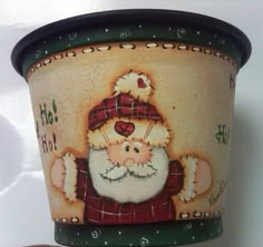 a ceramic pot with a santa clause on it's face and hand written words