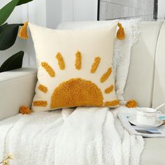 a white couch with a yellow sun pillow on it