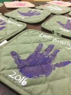 handprinted pot holders with purple paint on them