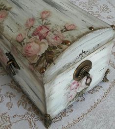 an old wooden box with flowers painted on the lid and handles sitting on a table