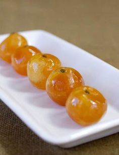 small oranges are arranged on a white plate