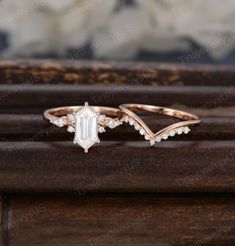 two gold rings with an emerald and white topazte stone on each one side