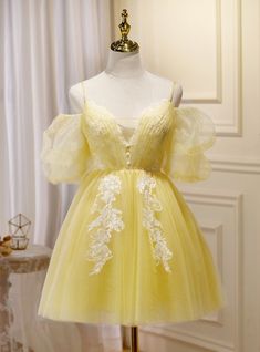 Tantalizing charm emanates from this vibrant yellow homecoming dress, a perfect blend of flirtatious style and delicate detailing. The bodice, with its sweetheart neckline and cascading lace appliques, contours gracefully, cinched by a band of shimmering beads. Ethereal puffed sleeves frame the shoulders, while the skirt's layers of frothy tulle promise to sway enticingly with every movement. This gown is a celebration of enchantment and poise, ideal for the young lady who commands the room with her bright, cheerful presence. Homecoming Dresses Yellow, Off The Shoulder Homecoming Dress, Short Princess Dress, Yellow Homecoming Dresses, Tulle Material, Professional Dress, Tulle Homecoming Dress, Prom Dresses Yellow, Short Prom Dress