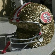 a football helmet made out of hay on the sidewalk