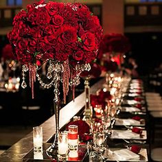 a long table is set with candles and red flower centerpieces for an elegant event