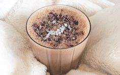 a glass filled with chocolate and nuts on top of a blanket