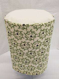 a white and green vase sitting on top of a table