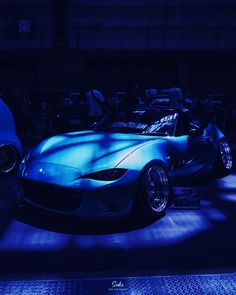 a blue sports car is parked in the dark