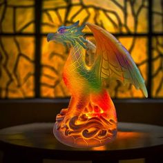 a colorful dragon figurine sitting on top of a table next to a window