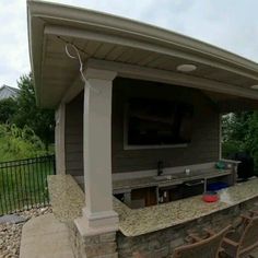 an outdoor kitchen with grill and seating area