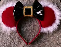 a red and black mickey mouse ears headband with white fur around it's ears