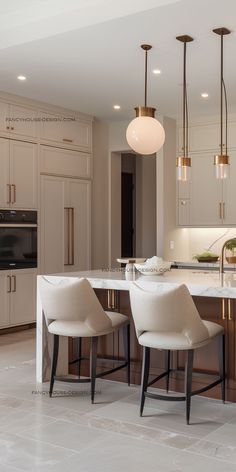 two white chairs sitting in front of a kitchen island with marble counter tops and pendant lights